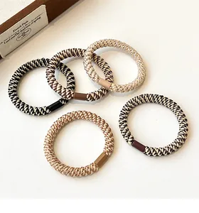 Detailed view of five high-elasticity woven hair ties in various coffee and earth tones