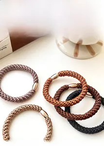 Detailed view of elastic hair ties in neutral tones with silver metal buckles
