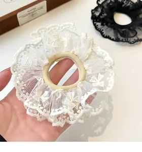 Close-up of elegant double-layered white lace scrunchie with intricate floral mesh detail
