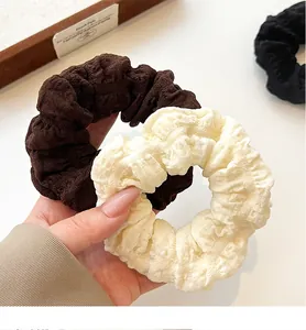 Macro detail of large cream and brown oversized scrunchies with soft fabric texture