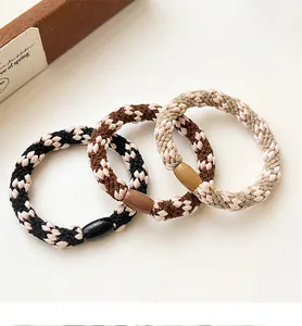 Detailed macro view of woven high-elasticity hair ties with retro houndstooth pattern texture