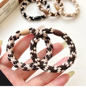 Close-up of woven high-elastic hair ties featuring houndstooth pattern and resin buckle