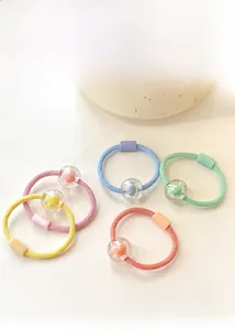 Detailed view of colorful macaron beaded elastic hair ties with mini plush ball charms