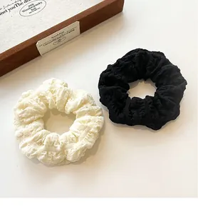 Detail of black and cream puff scrunchies with pleated bubble crepe fabric texture
