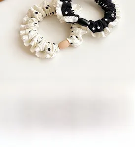 Close-up of fabric polka dot scrunchies featuring delicate lace edges and decorative beads