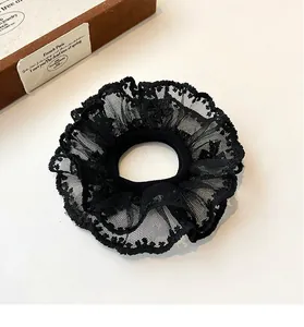 Close-up detail of double-layer black lace hair scrunchie with intricate mesh texture