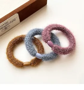 Detailed texture of thick plush hair scrunchies in brown, blue and purple tones