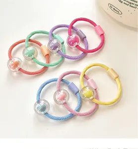 Detail of candy color beaded elastic hair bands with fuzzy pom-poms for kids