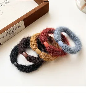 Close-up of thick plush elastic hair ties in four colors with smooth oval buckles