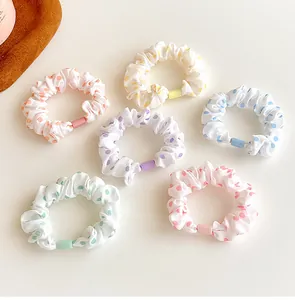 Close-up of 6-piece polka dot scrunchie set in assorted pastel colors with plastic buckles