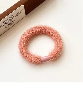 Close-up of pink plush elastic hair tie with soft texture and smooth decorative plastic buckle