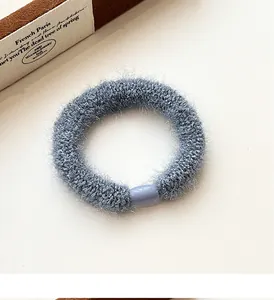 Detail of blue plush knit scrunchie with soft faux fur texture and seamless plastic connector