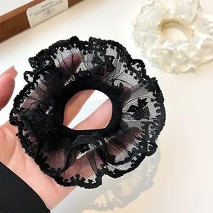 Double-layered lace scrunchie in black and cream for elegant ponytails and buns
