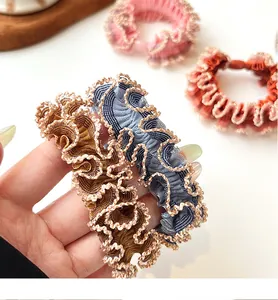 Close-up of assorted ribbed elastic hair ties featuring delicate gold wave lace trim
