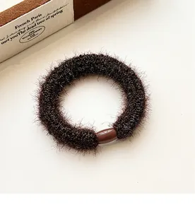 Close-up of thick coffee brown plush scrunchie with high elasticity and resin connector