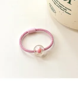 Close-up of pink beaded elastic hair tie with transparent sphere and candy color design