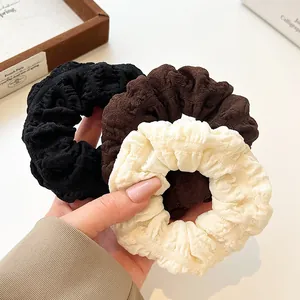 Three premium pleated scrunchies in black, coffee, and cream white textured fabric
