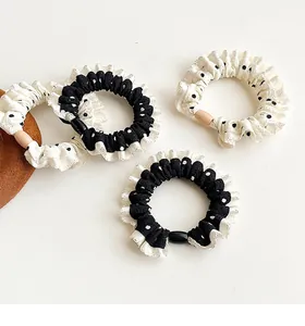 Detailed view of polka dot ruffle scrunchies set in black and white chiffon fabric
