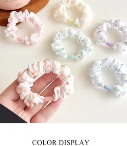 Detailed view of colorful polka dot scrunchies in pastel macarons shades on flat lay