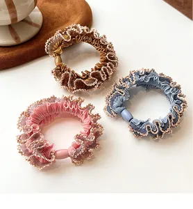 Detailed view of elastic hair scrunchies with wavy trim in coffee, pink, and blue