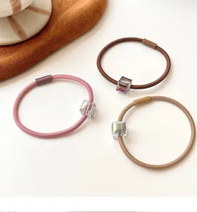 Close-up of elastic hair ties with rainbow crystal cubes in pink and brown tones