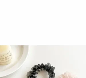 Detail of elegant black and champagne organza scrunchies in a lifestyle setting