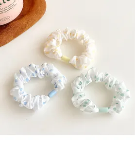 Three-piece set of polka dot fabric scrunchies in yellow, blue, and green colors