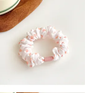Detailed view of polka dot scrunchie with soft pink accents and a pink buckle