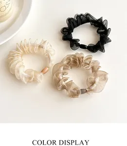 Detailed color display of organza scrunchies in black, cream white and champagne gold tones