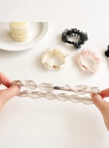Detail view of organza scrunchies in pastel tones with elastic wavy edges and sheer texture