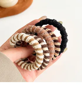 Detail van zachte crèmekleurige scrunchies met hoge elasticiteit en gebreide textuur