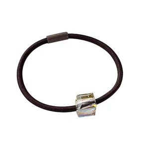Elastic brown hair tie featuring a large faceted iridescent crystal bead on white background