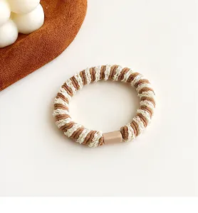 Detail van koffie en witte kant getextureerde haarelastiek met minimalistische gesp