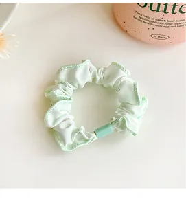Detail of light green floral scrunchie with square buckle and sweet cherry pattern