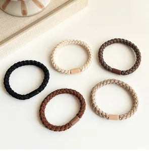 Close-up of earth-toned braided hair ties with smooth cylindrical metal fasteners