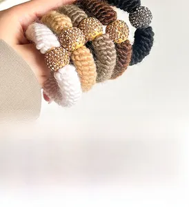 Detail of knitted hair scrunchies in earth tones with sparkling rhinestone balls
