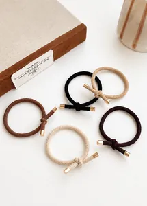 Detail view of 4-pack elastic hair ties in earthy tones with gold metal caps