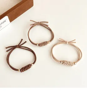 Détail d'élastiques tressés à haute élasticité avec perles dorées aux tons terre