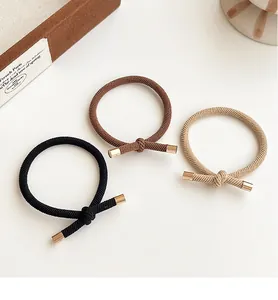 Detail of high-elasticity hair ties with gold metal buckles in three earth tones