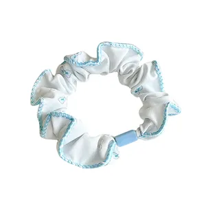 Light blue floral scrunchie with elastic chiffon fabric and blue hem for bun hair