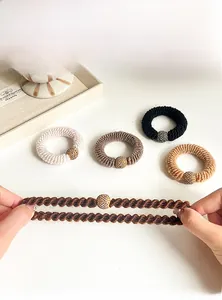 Close-up of thick knitted hair ties with rhinestone beads in natural earthy tones