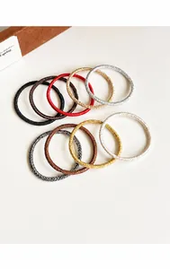 Detalle macro de gomas de pelo brillantes en oro, rojo y plata con textura trenzada