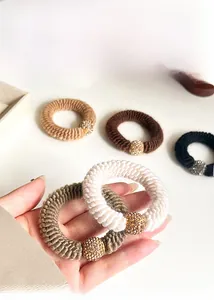 Detail of thick knitted hair ties with sparkling rhinestone beads in earthy tones