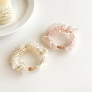 Elegant organza scrunchies in white and pink colors with small beads on a clean background