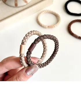 Macro detail of braided high-elastic hair ties in neutral earth tones with plastic clasp