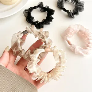 Elegant organza scrunchies set in black, gold, and pink colors for hair styling