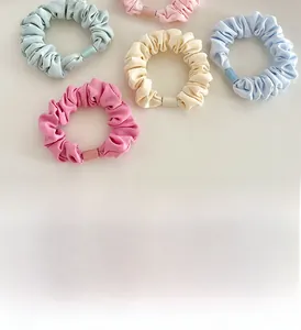 Close-up of colorful scrunchies with matte buckles showing fabric texture and pleats