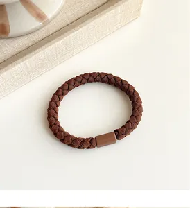 Detailed view of coffee brown braided hair tie with smooth cylindrical connector