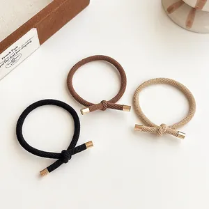 Elastic knotted hair ties in black, coffee, and beige with elegant gold metal cylinder caps