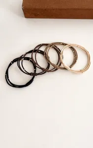 Détail d'élastiques à cheveux triple rang aux tons terreux avec perles dorées